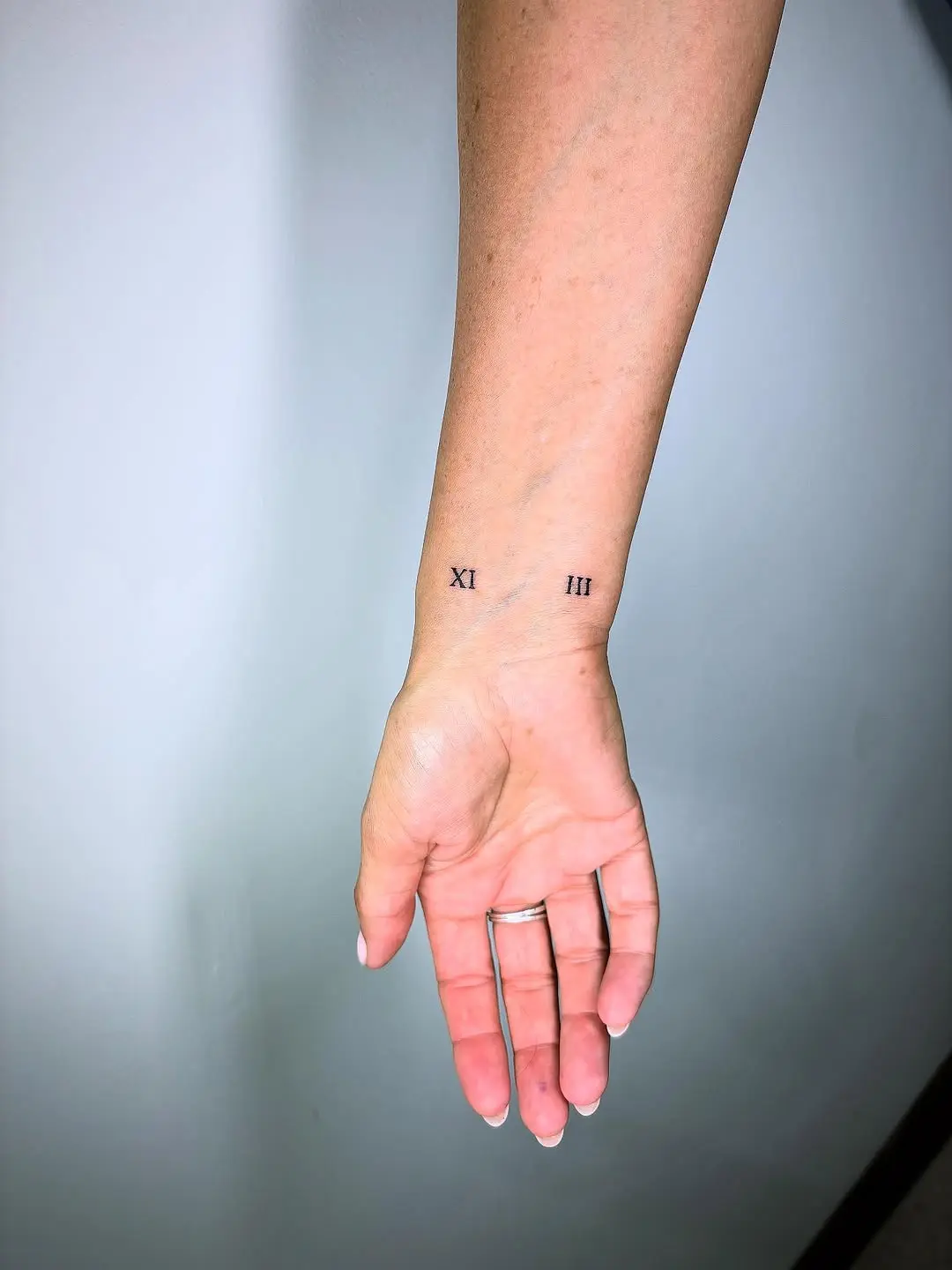 Elegant Roman Numeral Wrist Tattoo Design