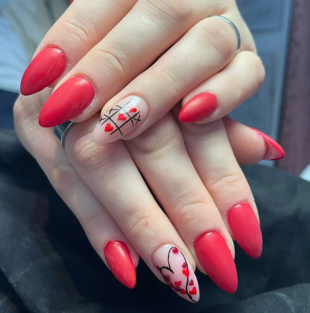 Bold red nails with charming heart accents