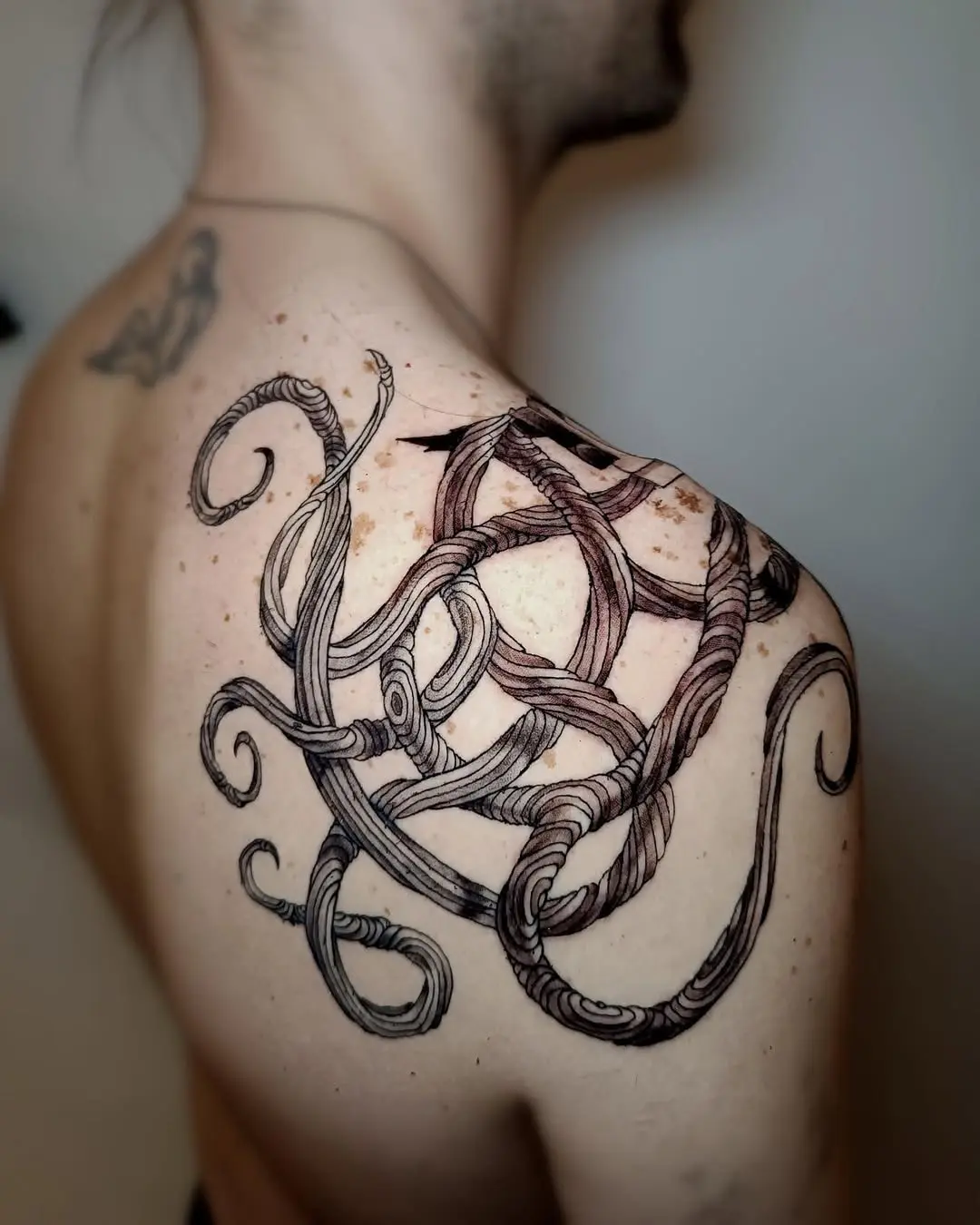 Intricate roots tattoo with flowing octopus design