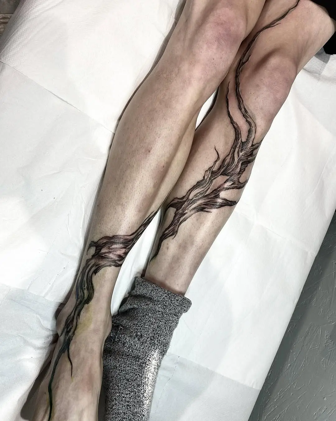 Artistic roots tattoo flowing down the leg