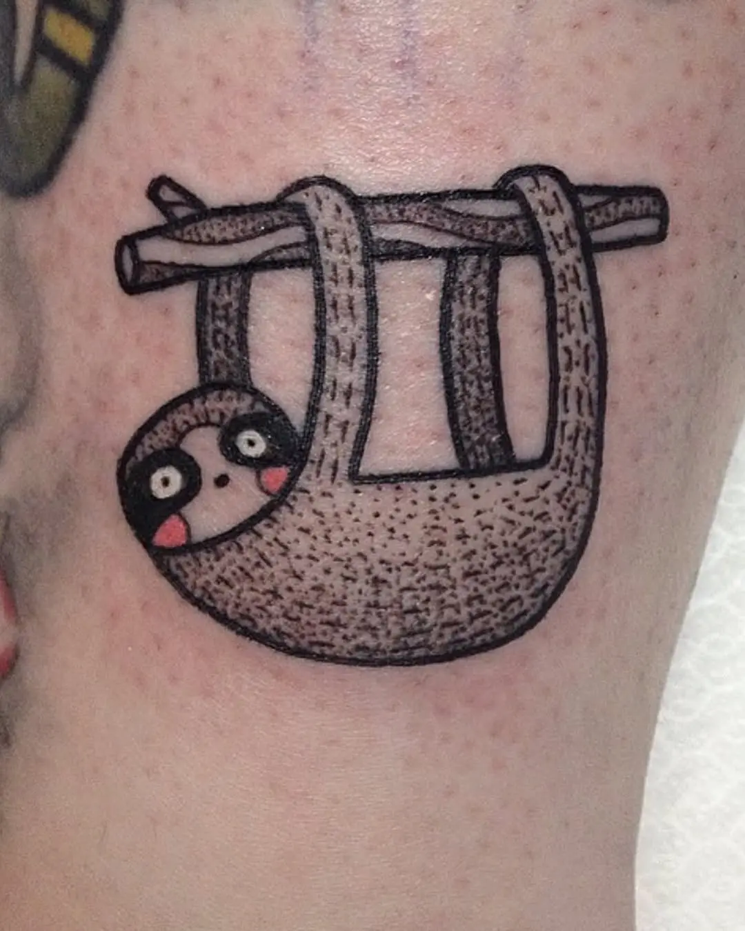 Adorable sloth tattoo hanging from a branch
