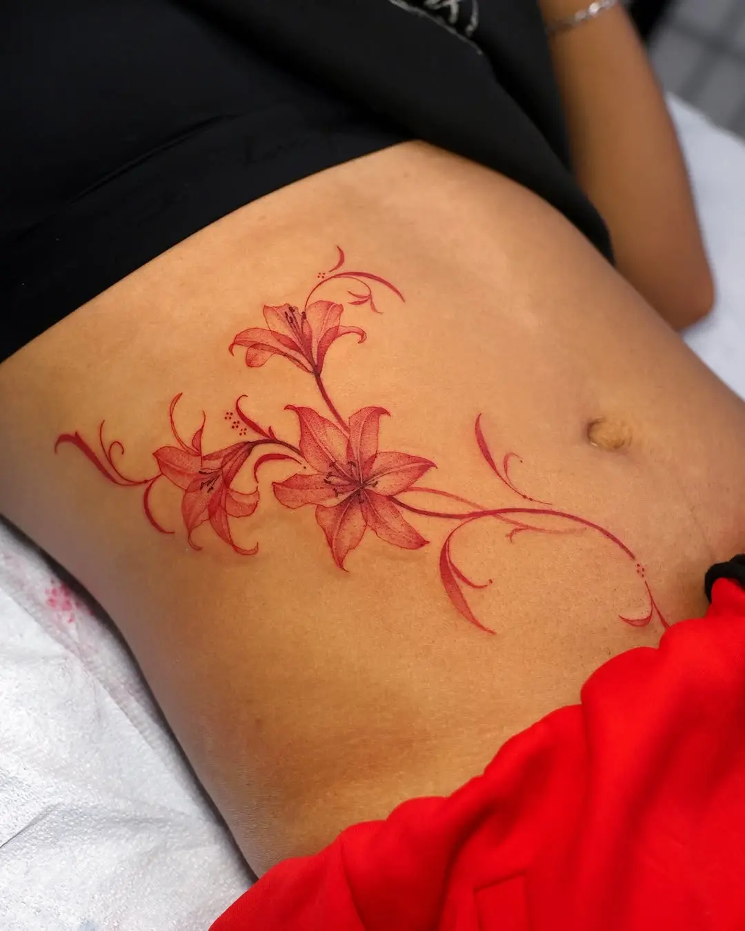 Elegant red lily tattoo on the skin