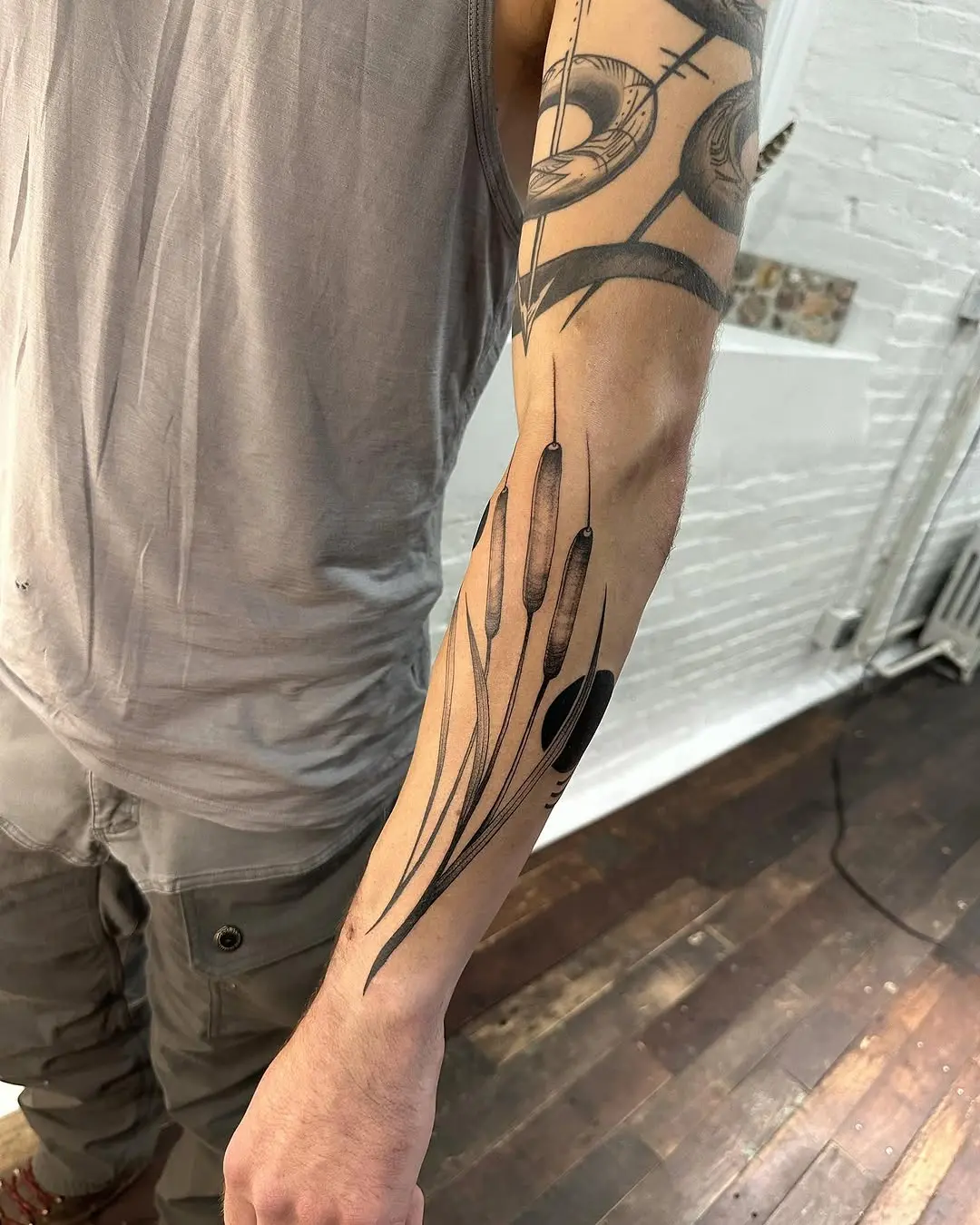 Elegant cattail tattoo captures nature's beauty.