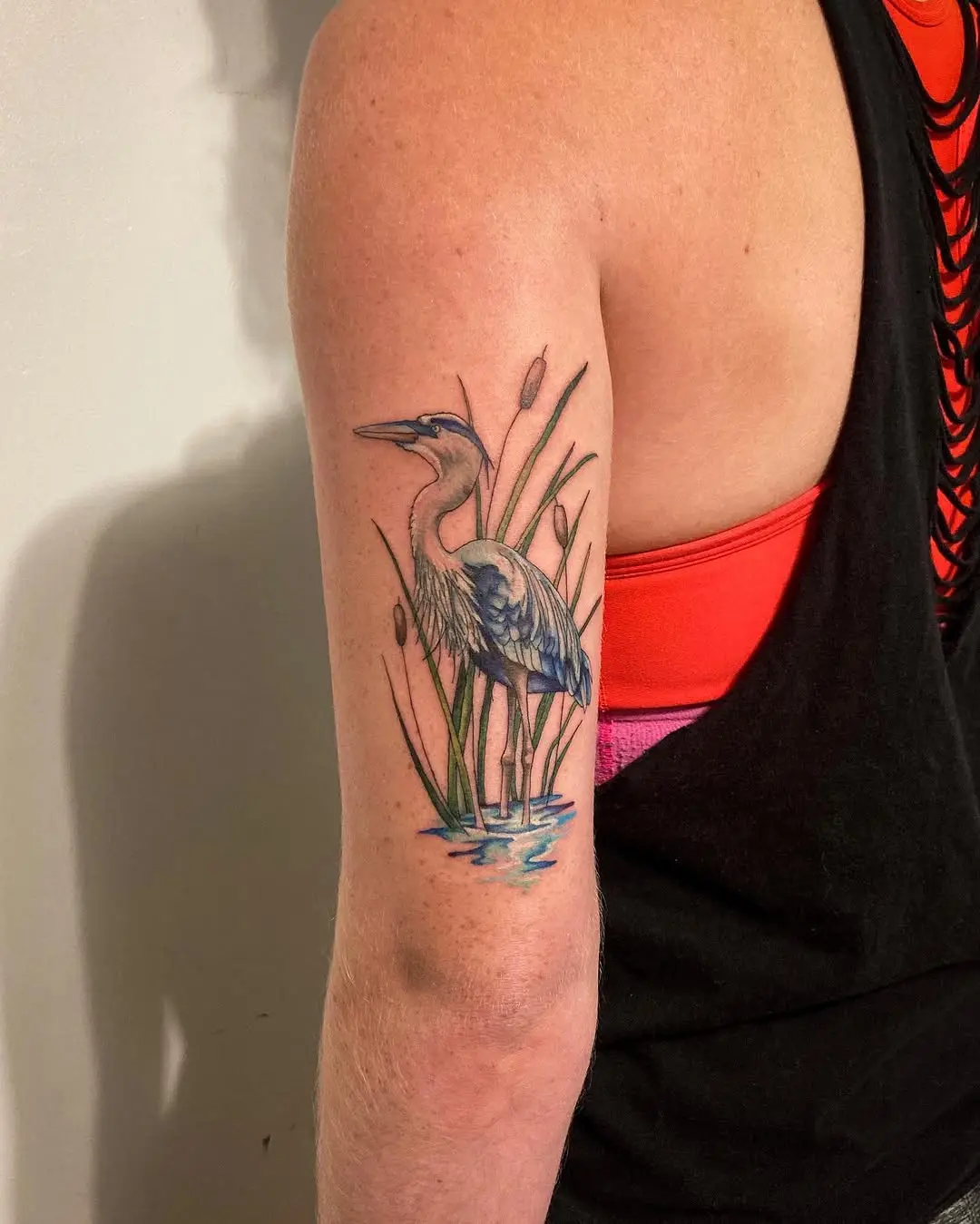 Vibrant heron amidst cattails tattoo design