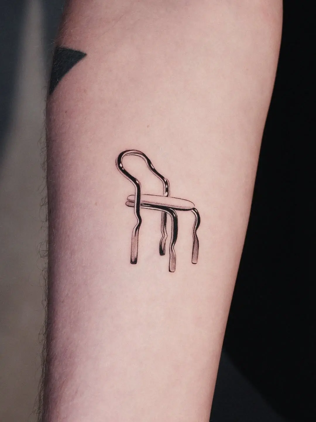 Minimalist chair tattoo with artistic flair
