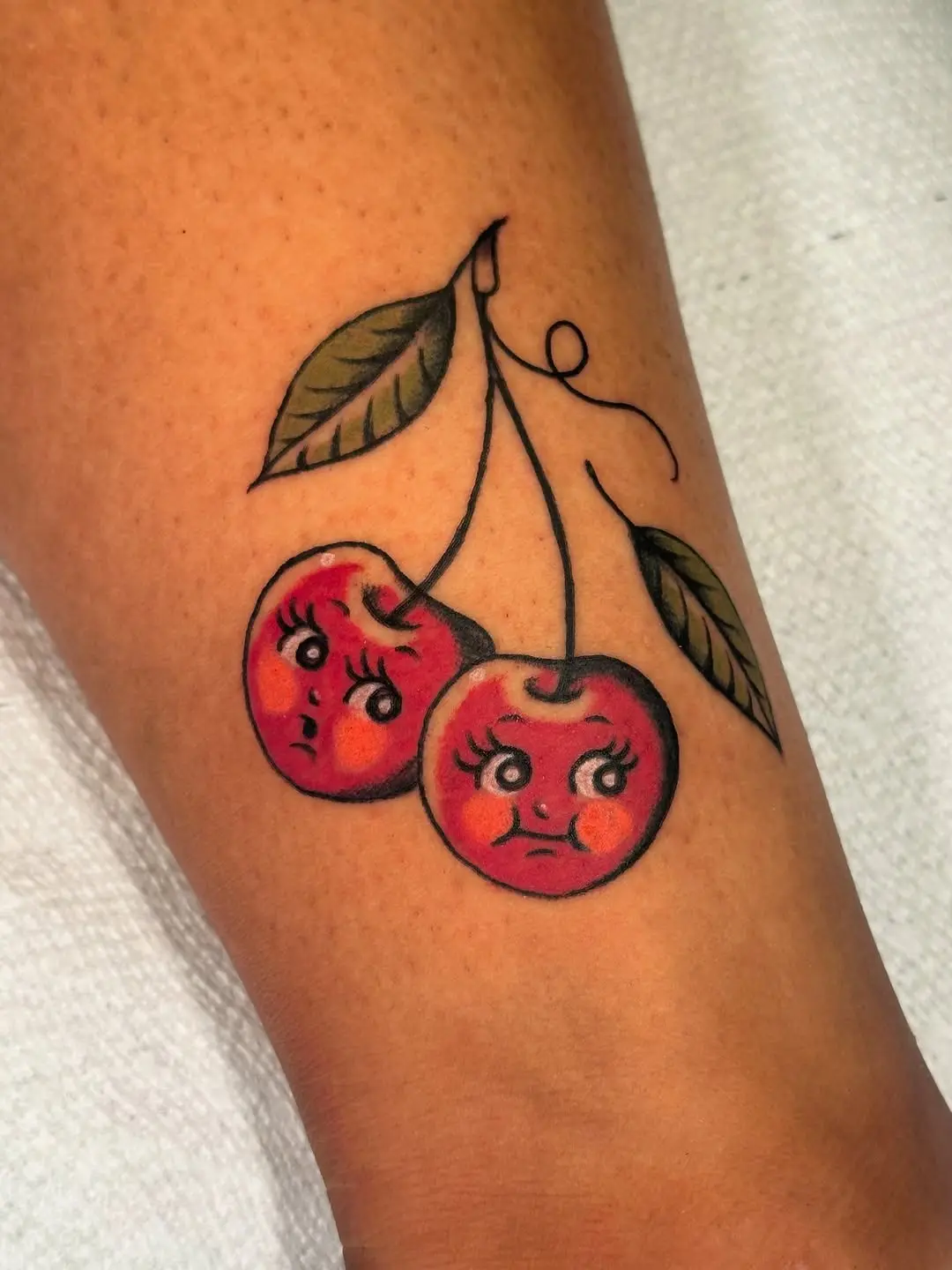 Whimsical cherry tattoo with playful expressions