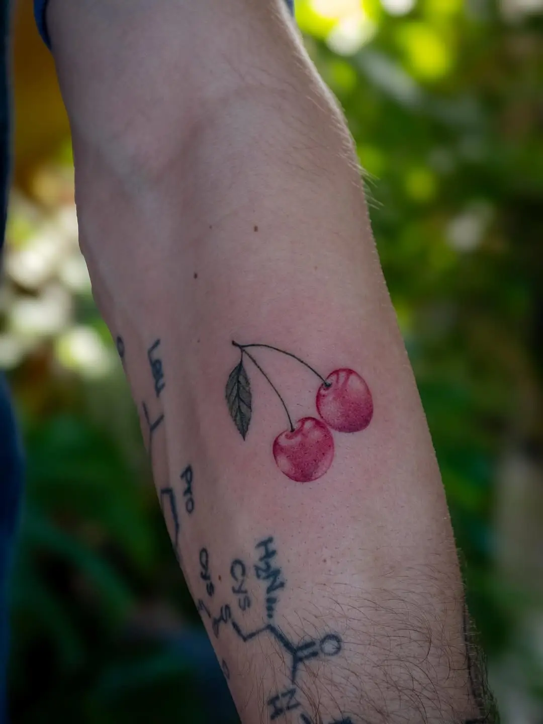 Charming cherry tattoo with vibrant watercolor style
