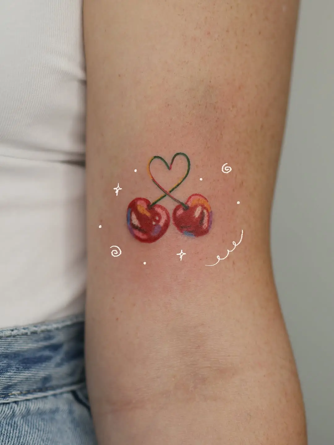 Vibrant cherry tattoo with heart charm