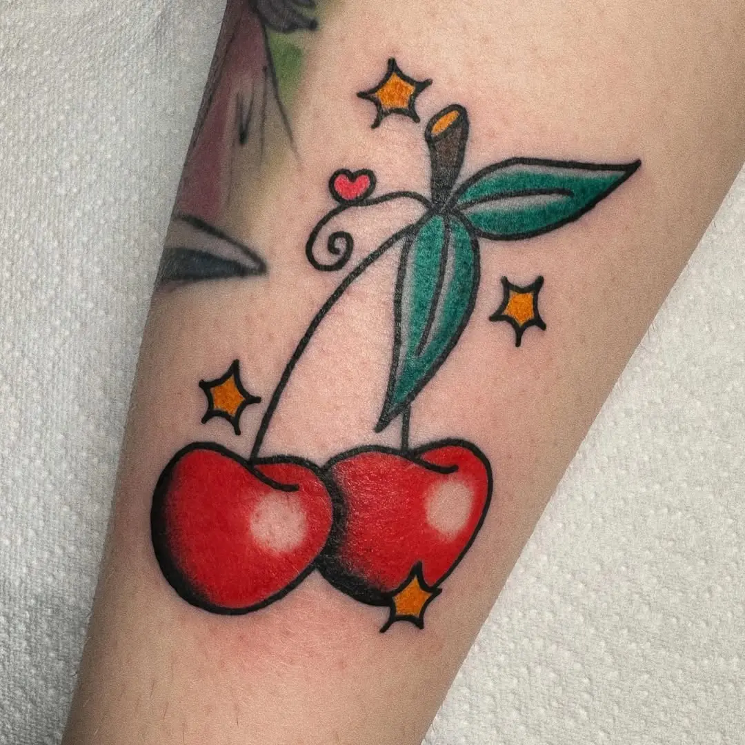 Vibrant cherry tattoo adorned with stars