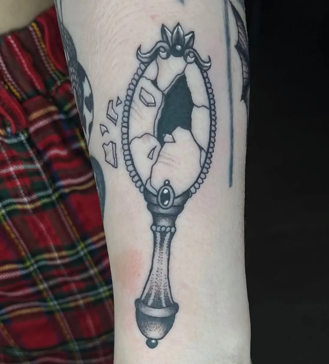 Unique cracked mirror tattoo design on arm