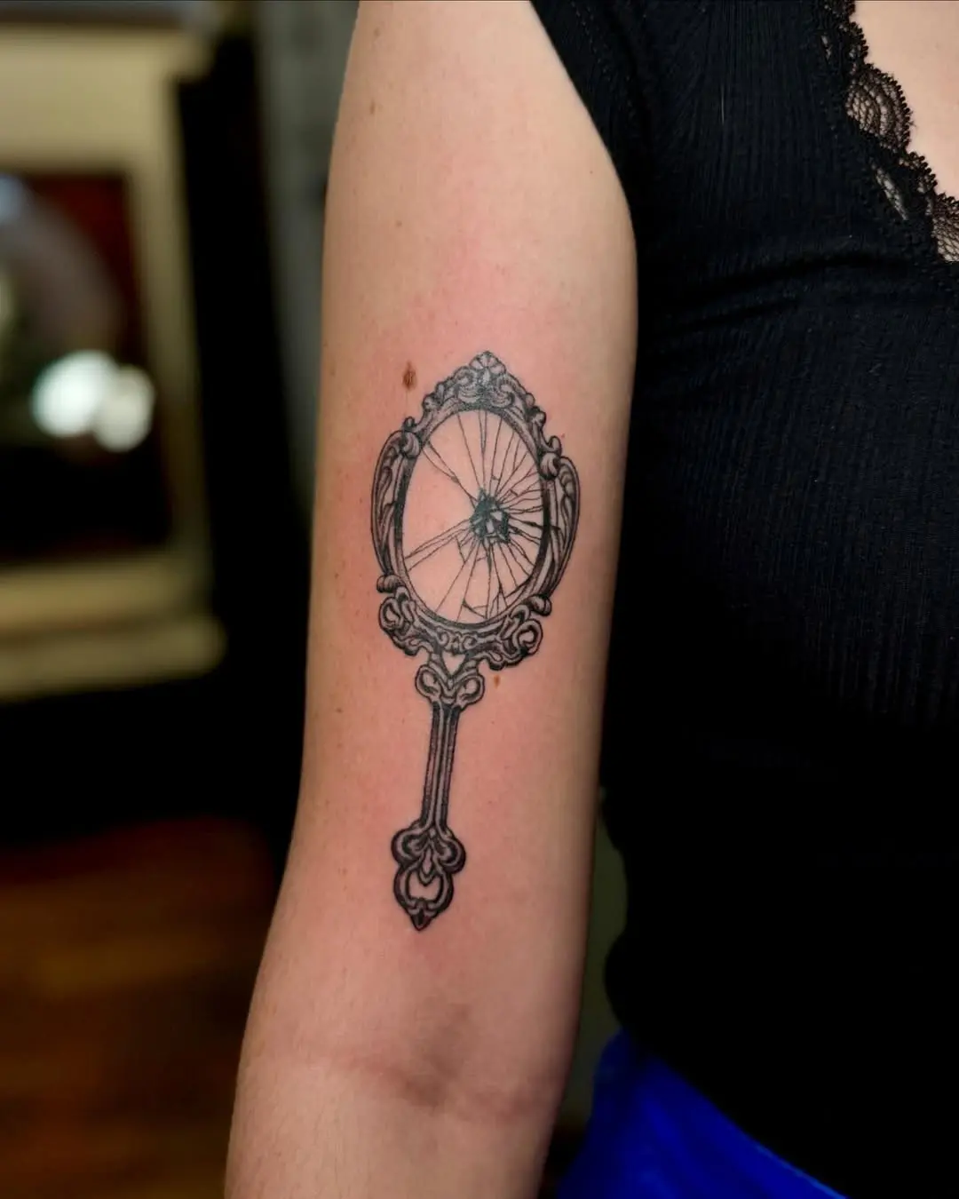 Elegant cracked mirror tattoo with vintage charm