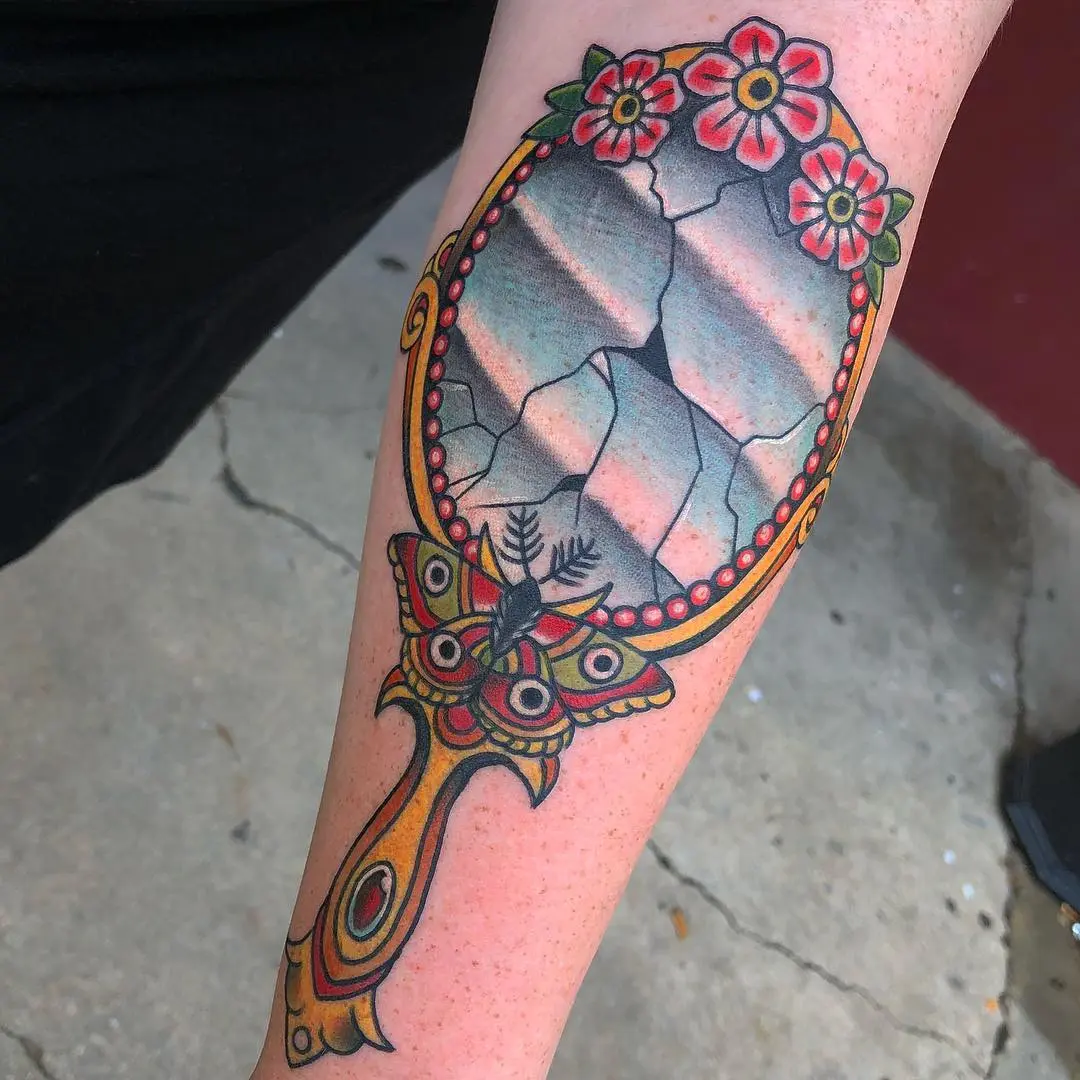 Unique cracked mirror tattoo with floral accents