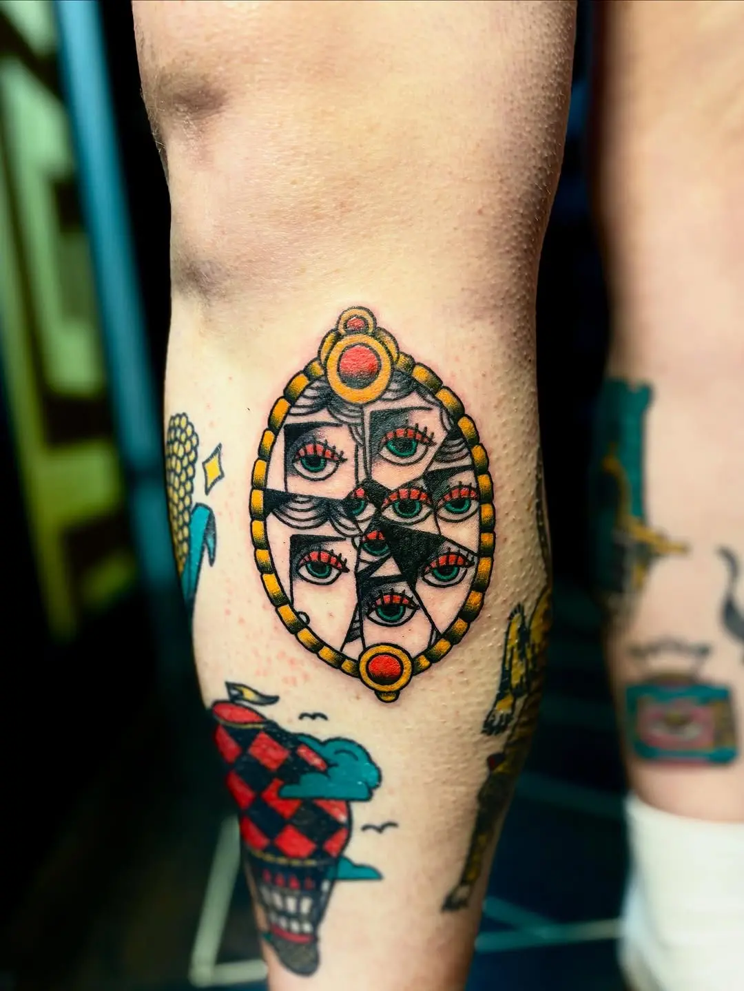 Unique cracked mirror tattoo design featuring multiple eyes