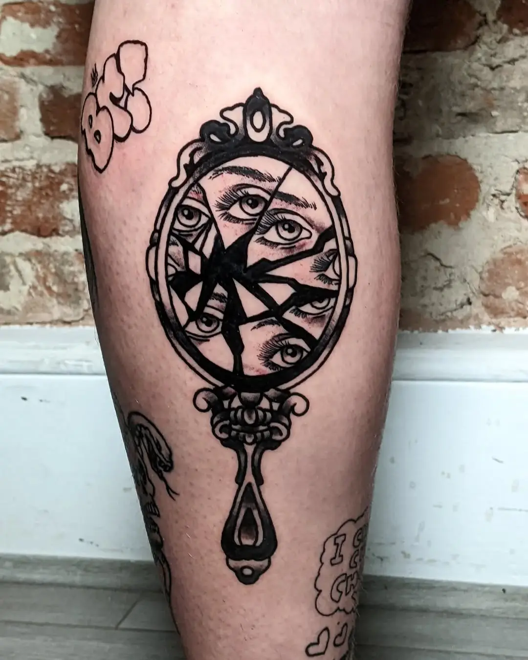 Unique cracked mirror tattoo with hidden eyes