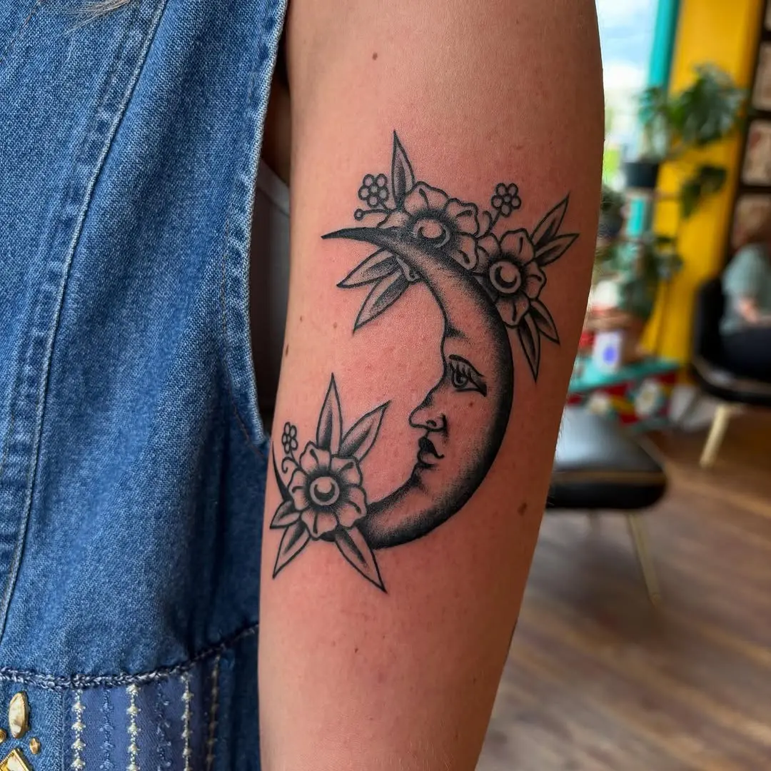 Elegant crescent moon tattoo adorned with flowers