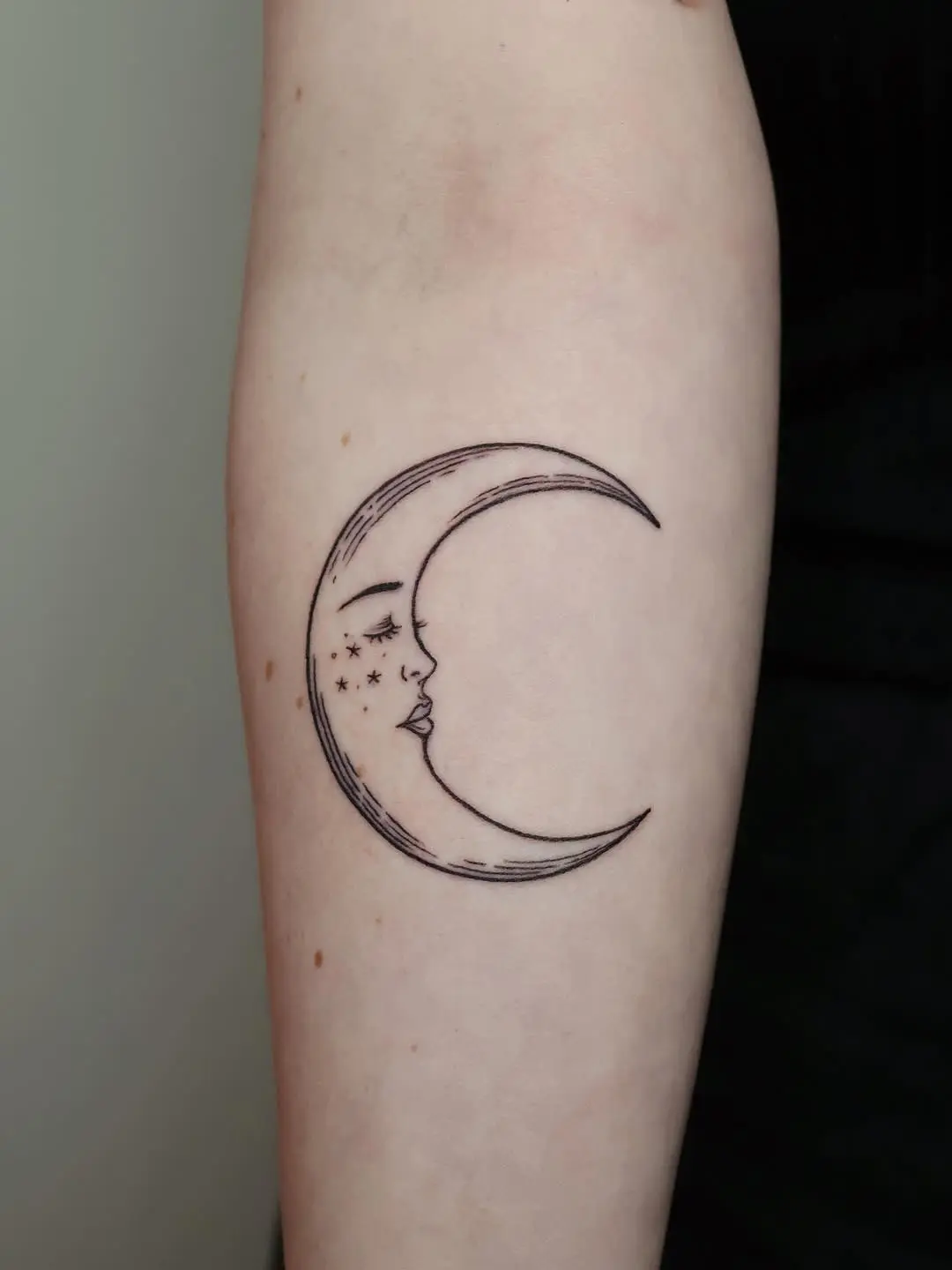 Elegant crescent moon with face and stars design.