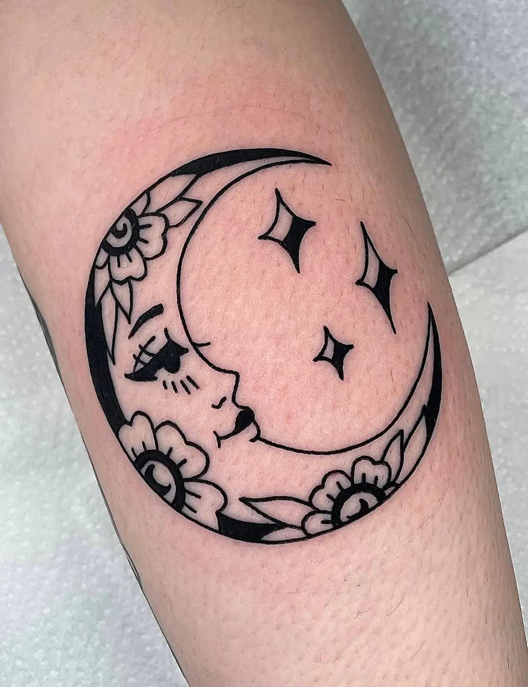 Detailed crescent moon tattoo with floral design
