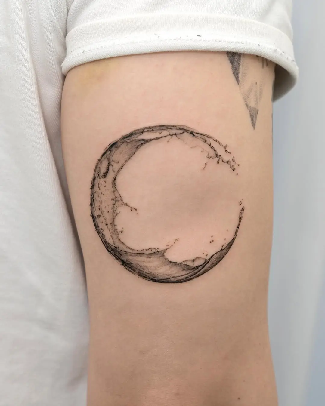 Minimalistic crescent moon tattoo on arm
