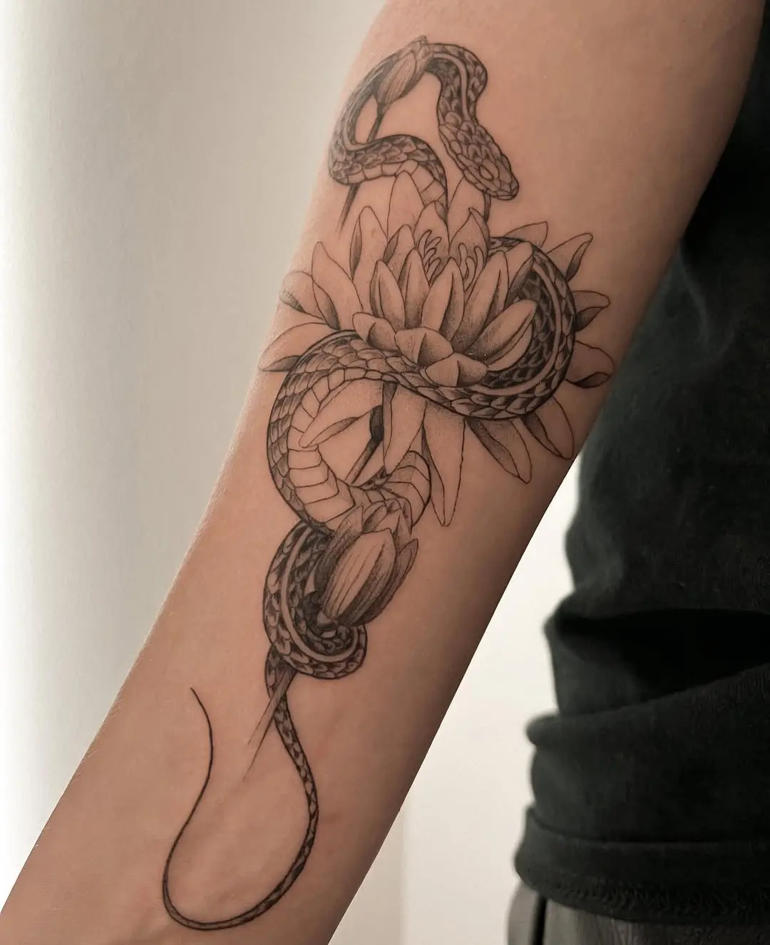 Intricate water lily and snake tattoo design