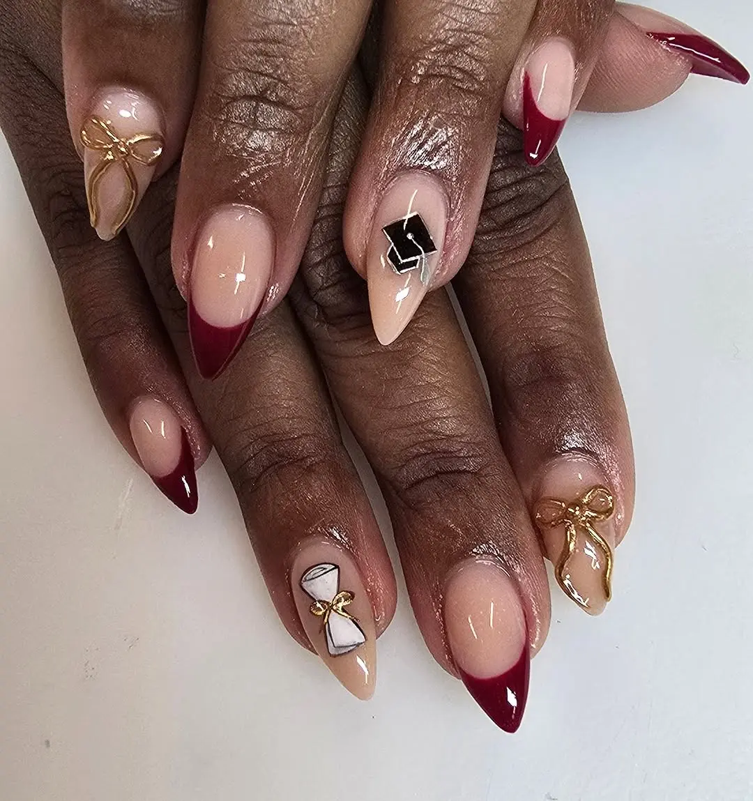 Chic graduation nails with red and gold accents