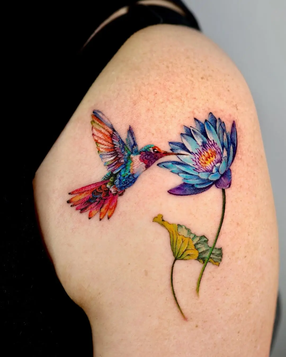 Colorful hummingbird and water lily tattoo design