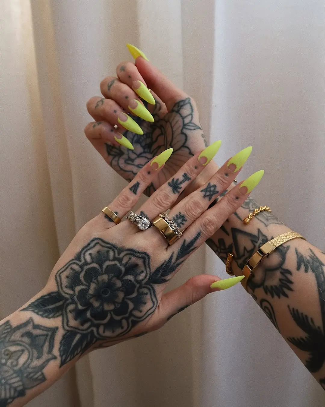 Vibrant neon nails with stunning tattoos