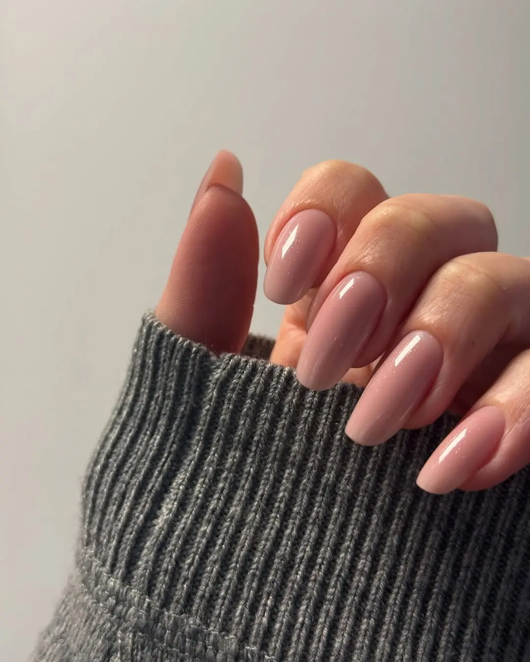 Elegant pink nails paired with cozy sweater vibes