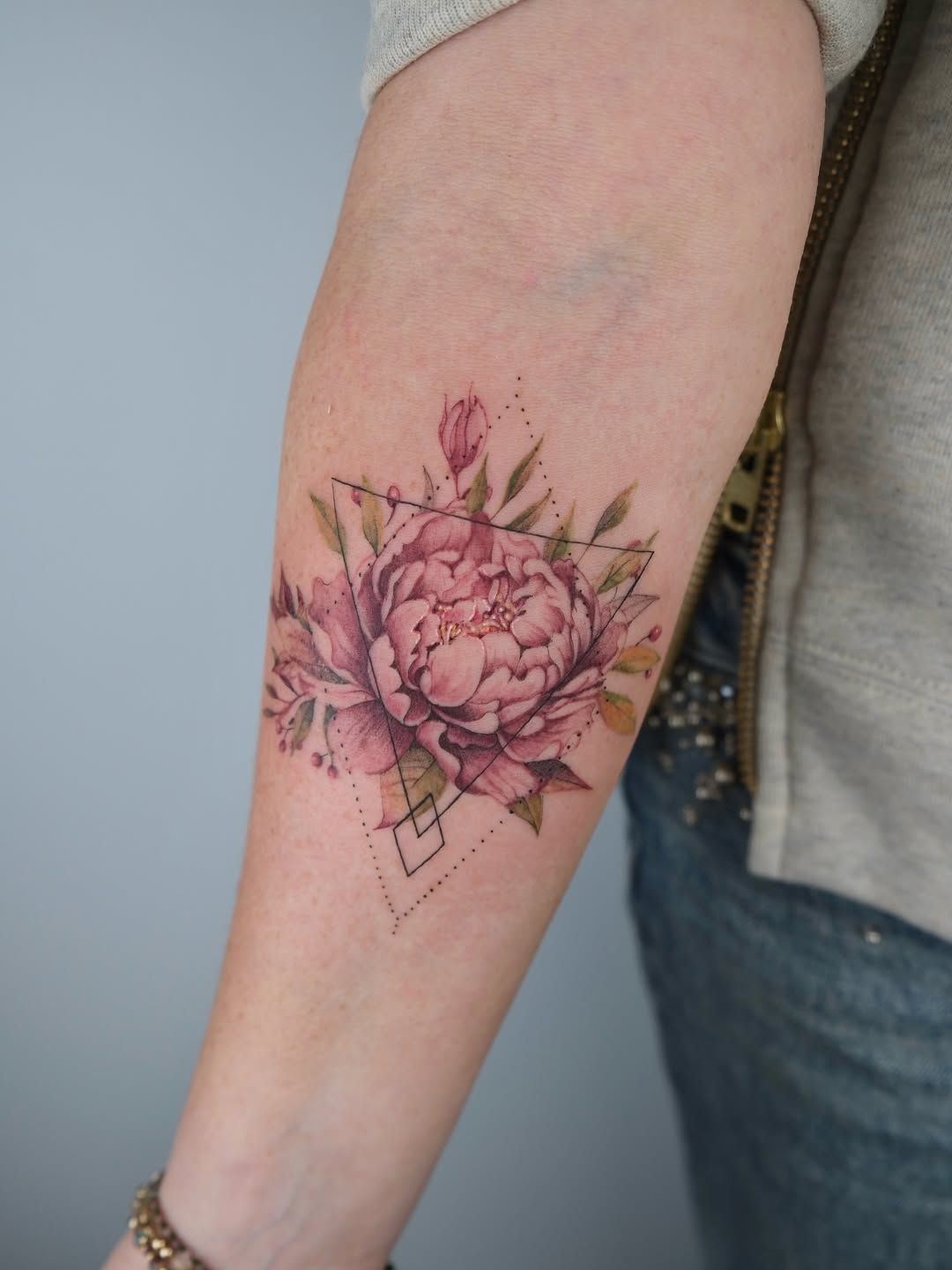 Elegantly crafted peony tattoo with geometric elements