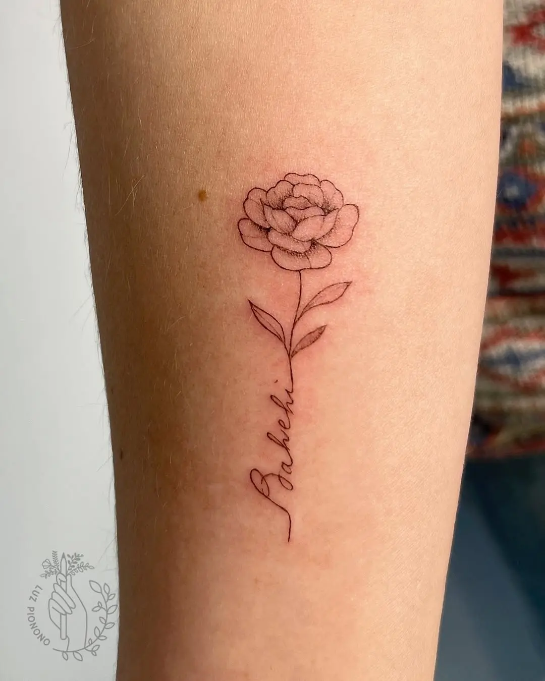 Delicate peony tattoo with whimsical lettering