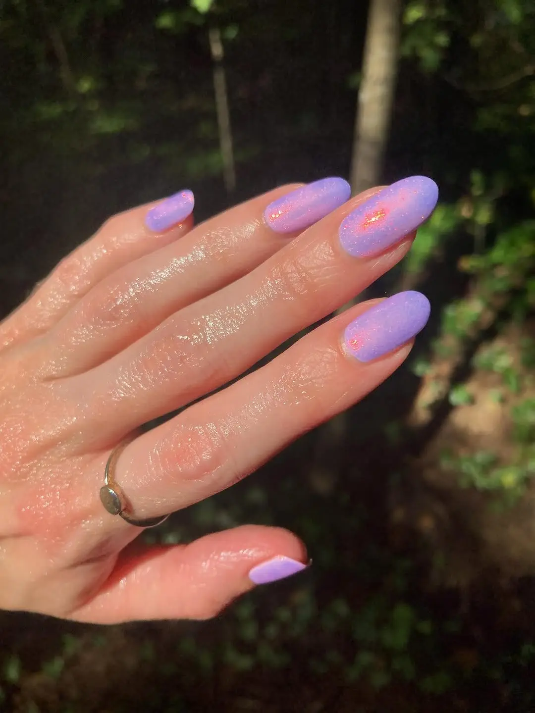 Glittery periwinkle nails in a natural setting