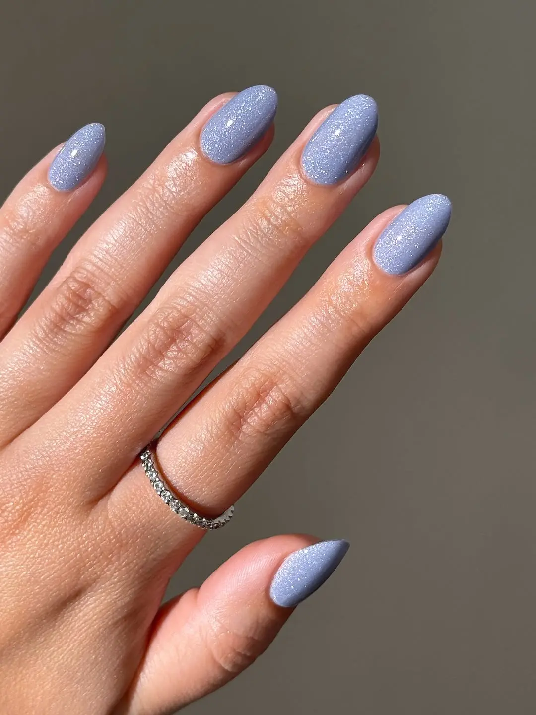 Elegant periwinkle nails with a sparkling finish.