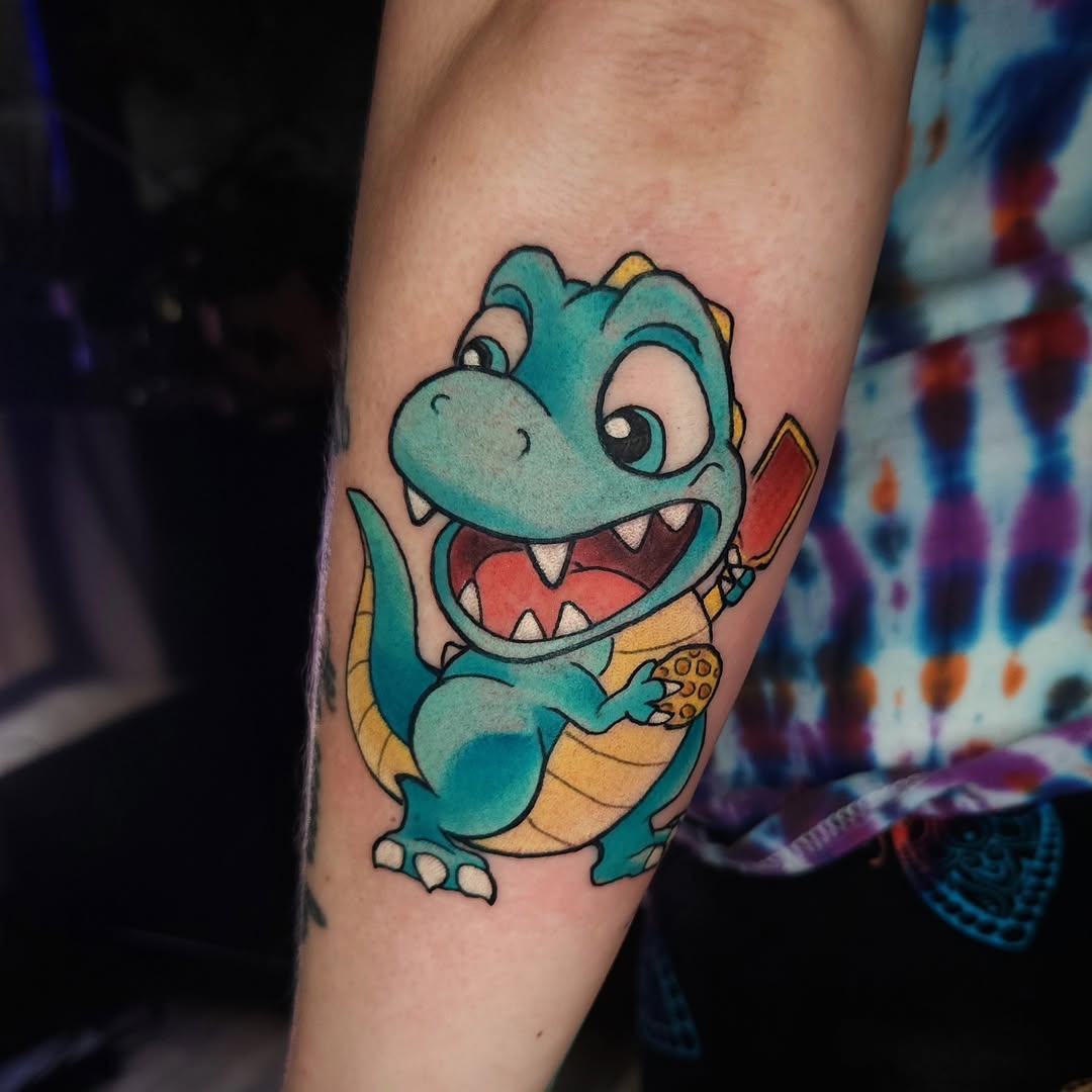 Playful dinosaur tattoo with pickleball paddle