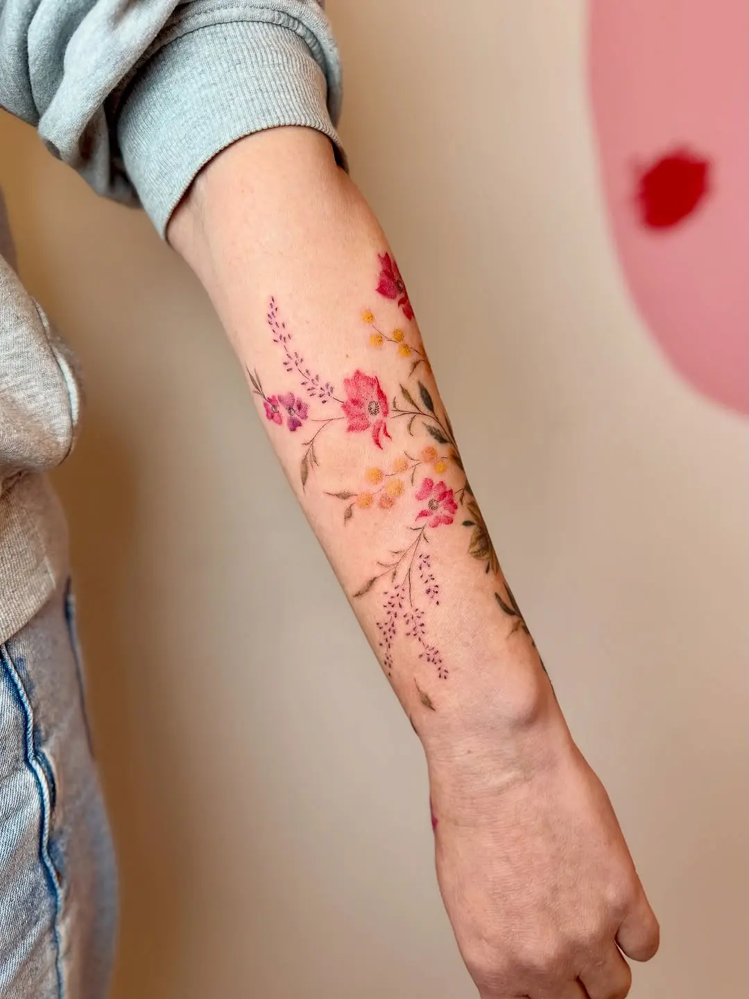 Vibrant floral poppy tattoo on forearm