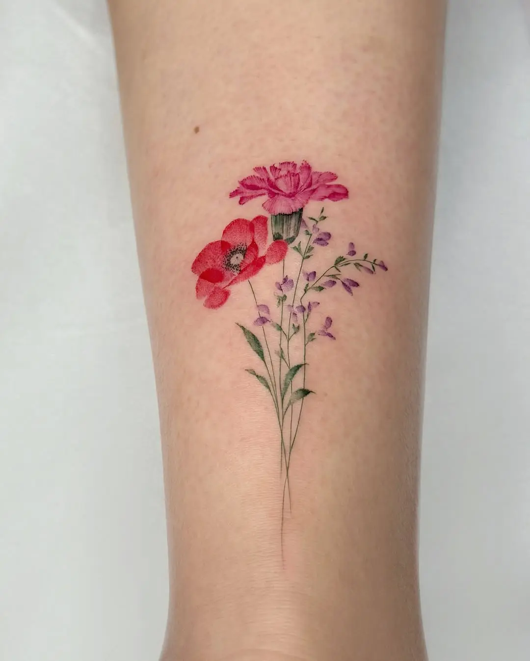 Vibrant poppy tattoo with delicate floral details