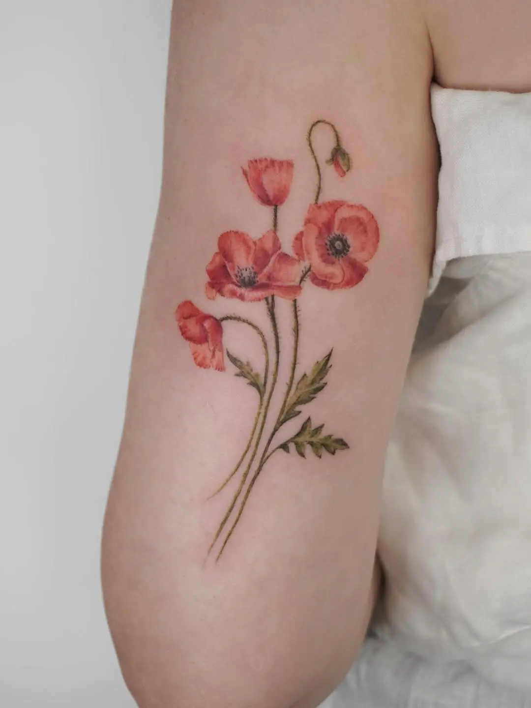 Elegant poppy tattoo with delicate floral details