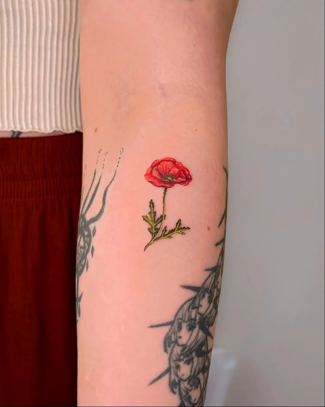 Elegant poppy tattoo on forearm