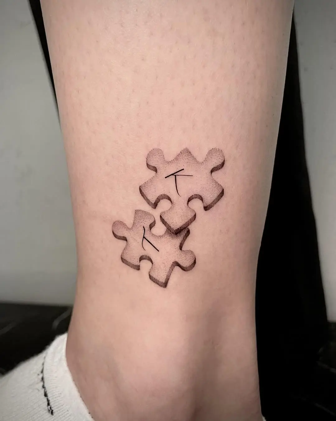 Intricate puzzle piece tattoo on the ankle