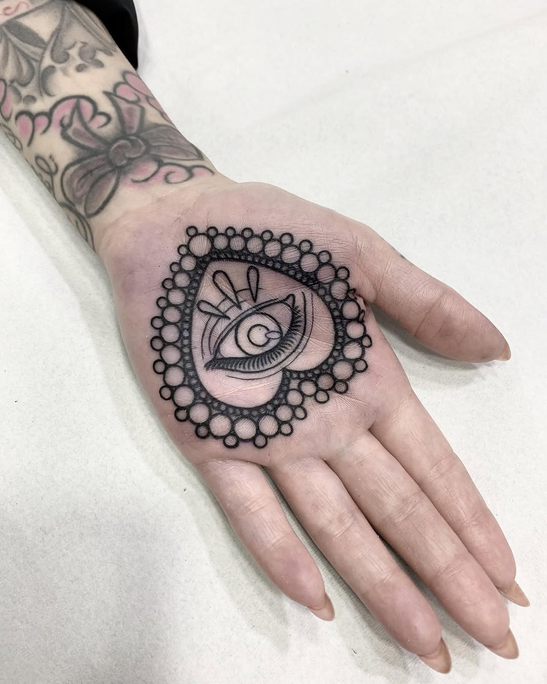 Intricate heart-shaped eye tattoo design