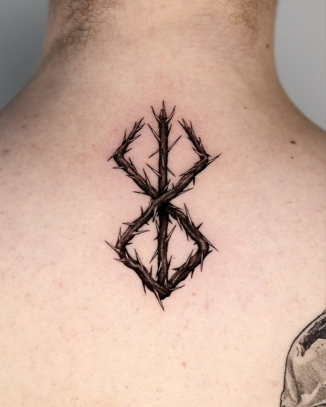 Intricate thorn design tattoo on back.