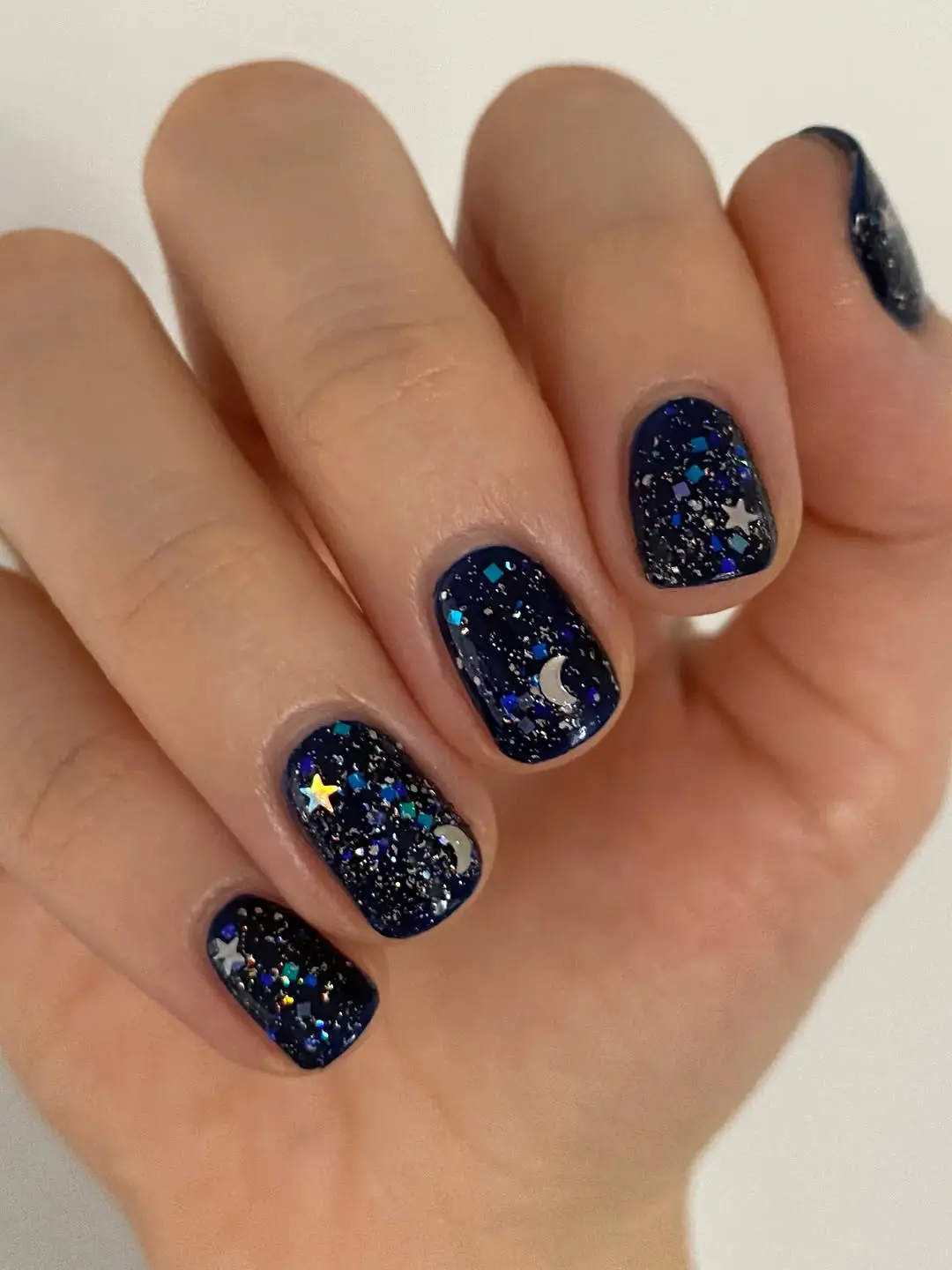 Glistening navy winter nails with starry accents