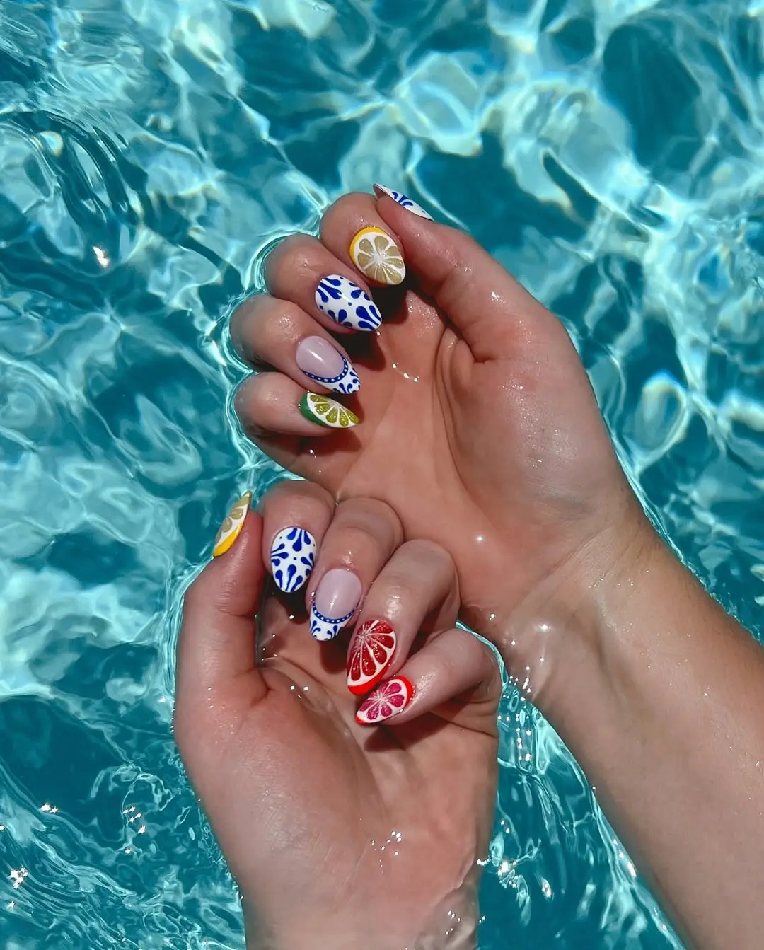 Colorful summer fruit nail art in sunlit water
