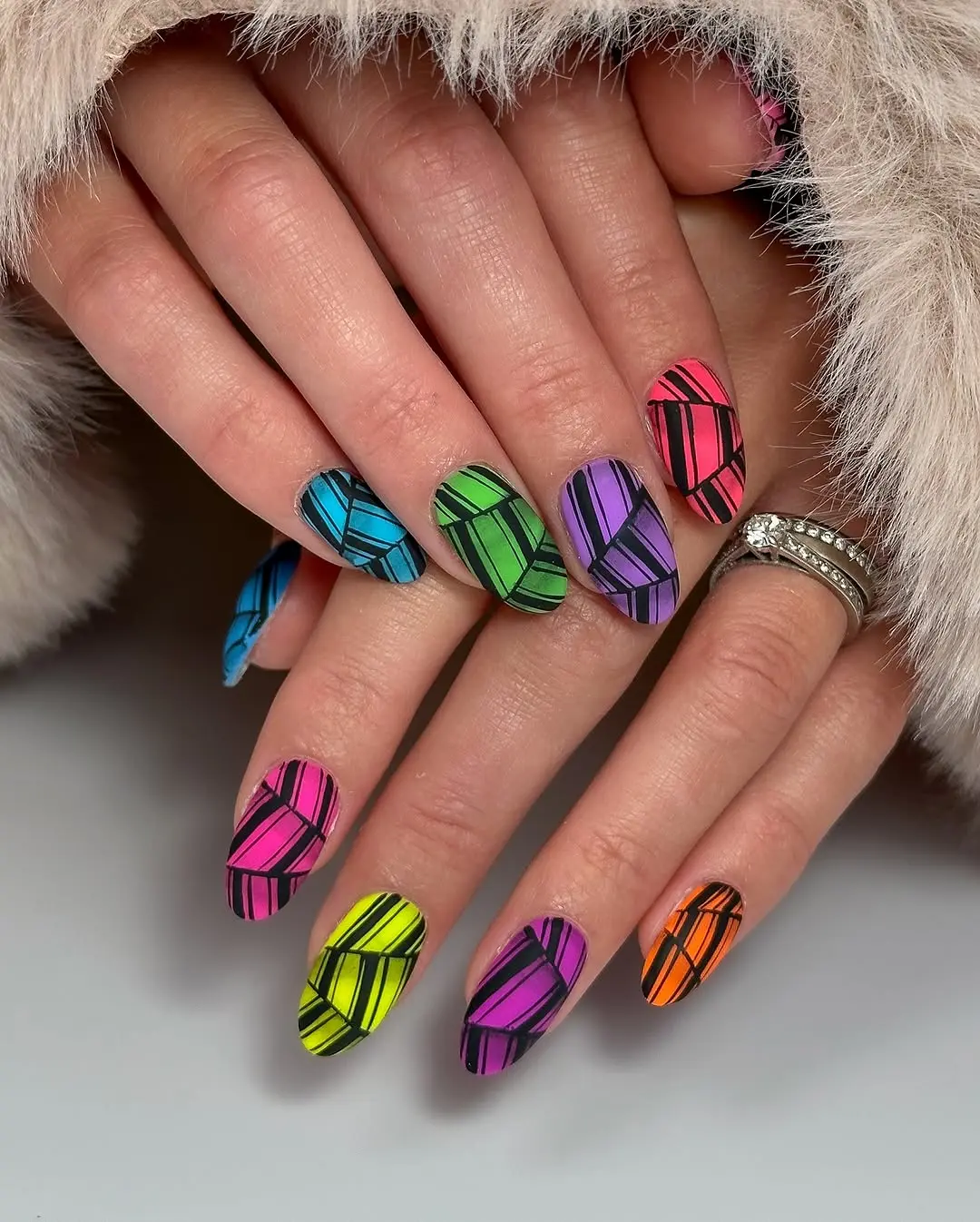 Bold geometric patterns on vibrant neon nails