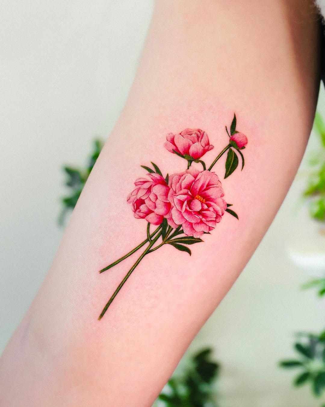 Delicate pink peonies on a bare arm