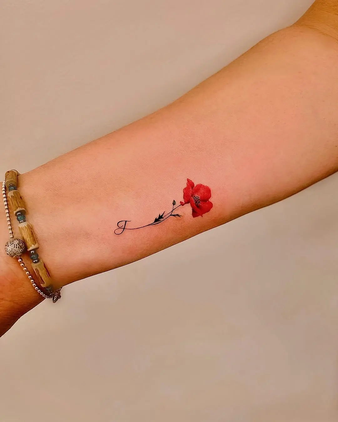 Elegant poppy tattoo on a delicate arm