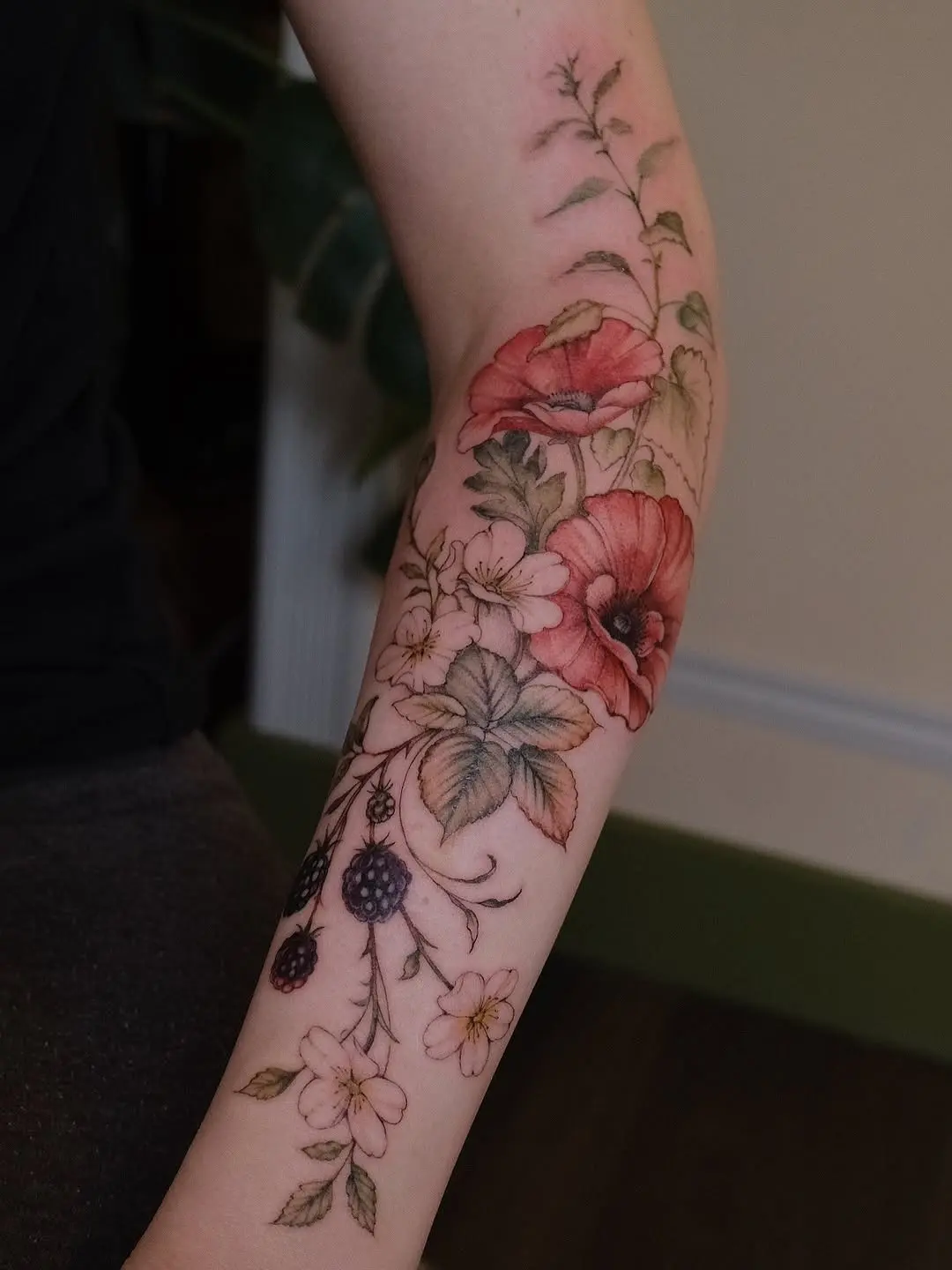 Vibrant floral tattoo design on the elbow