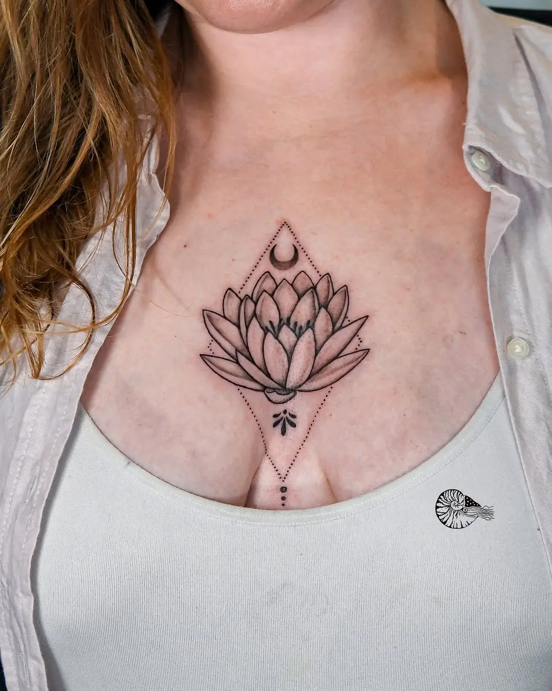 Elegant water lily tattoo above the chest.