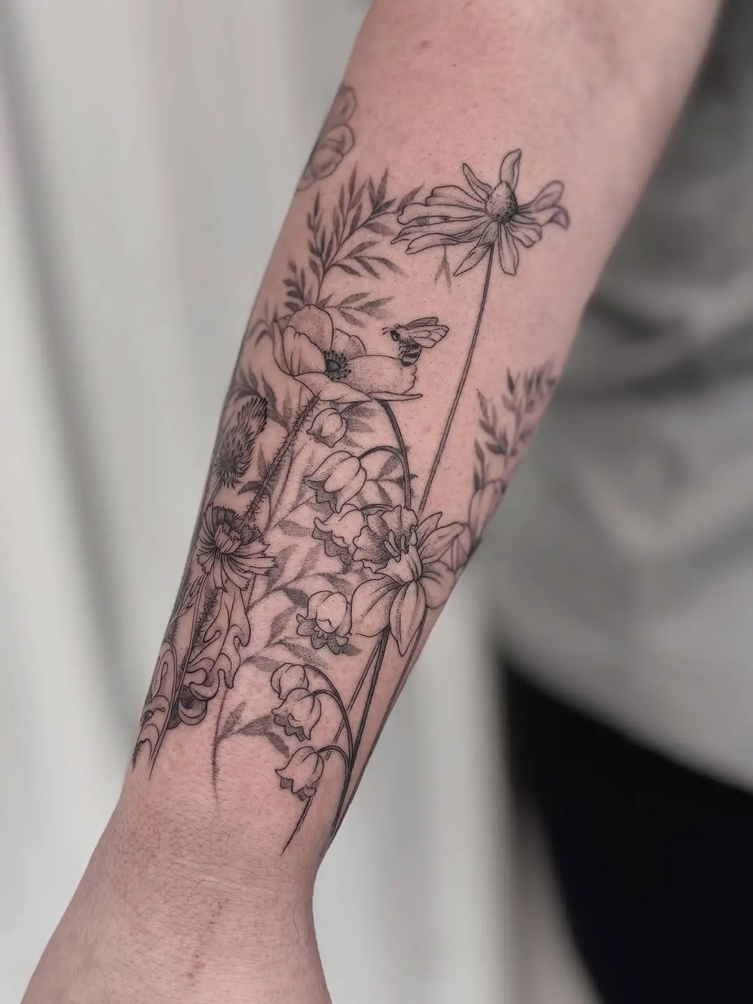 Graceful wildflower design on a forearm tattoo