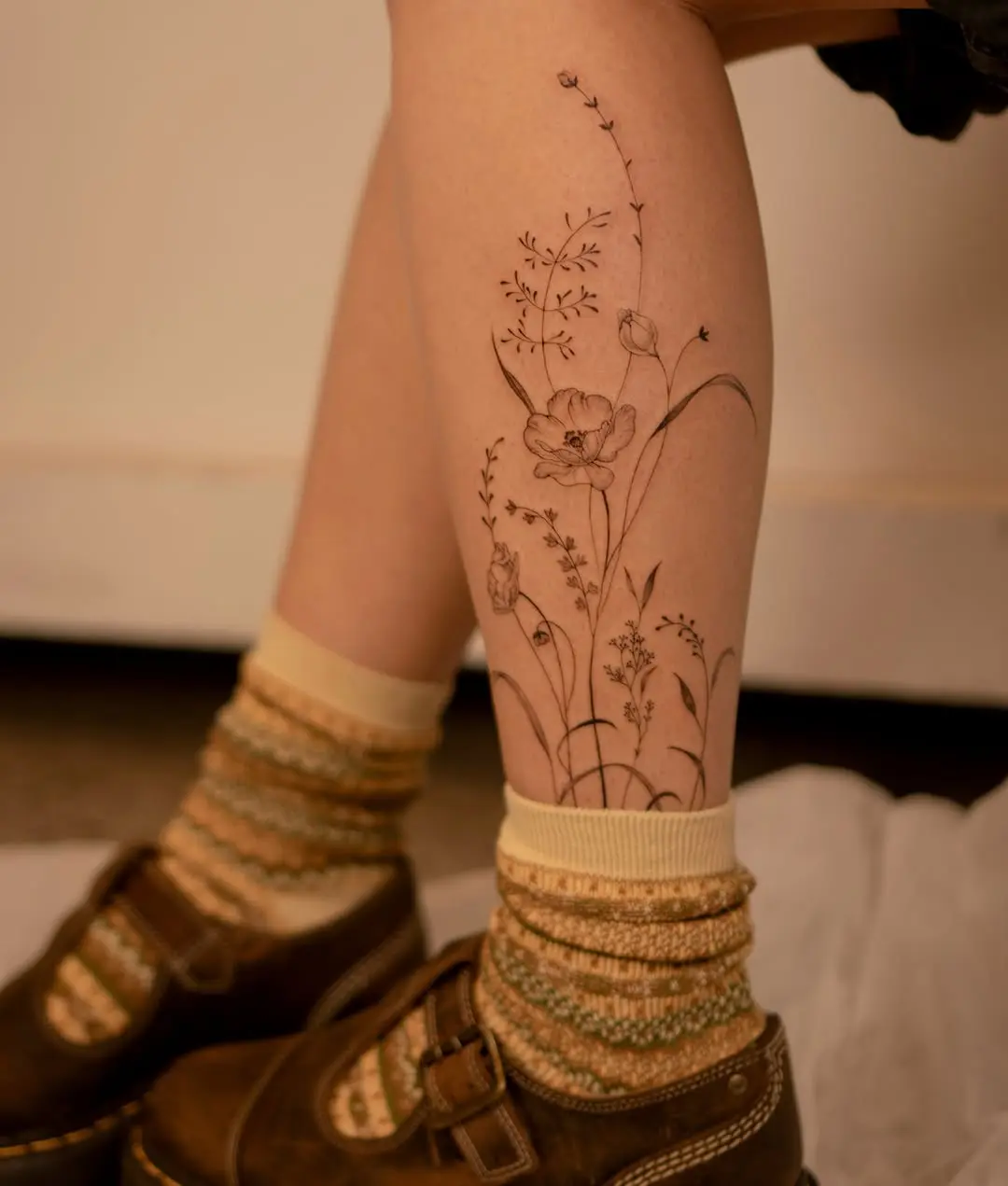 Charming wildflower tattoo on a leg