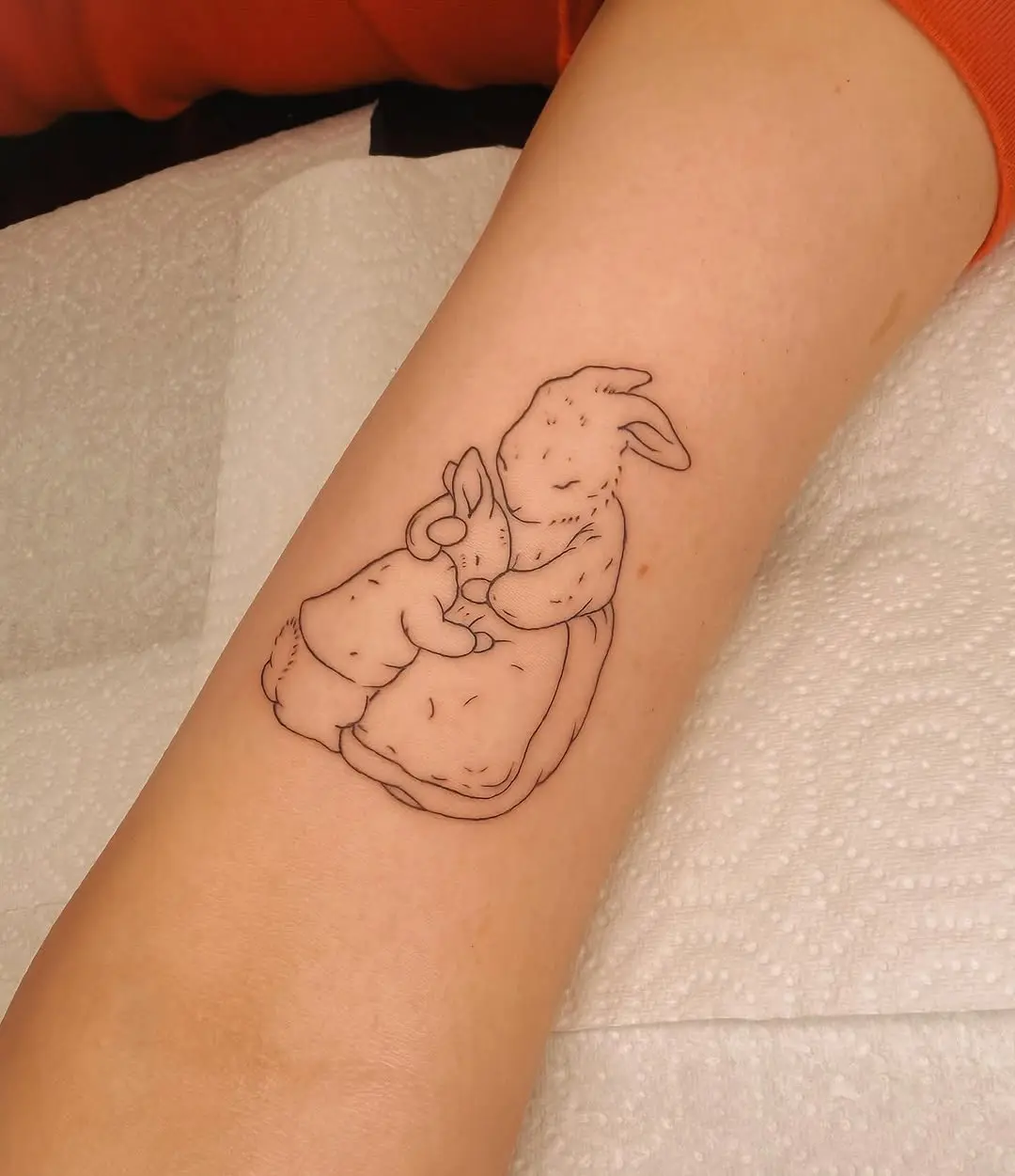 Tender tattoo showcasing mother and child rabbits