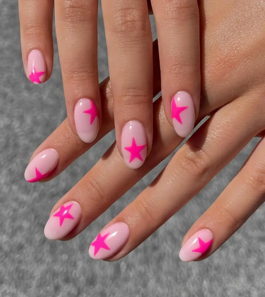 Vibrant pink star accents on Barbie nails